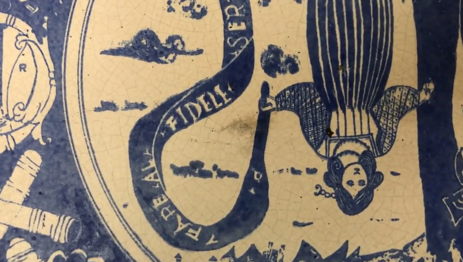 Antique ceramic featuring various images and patterns in blue.