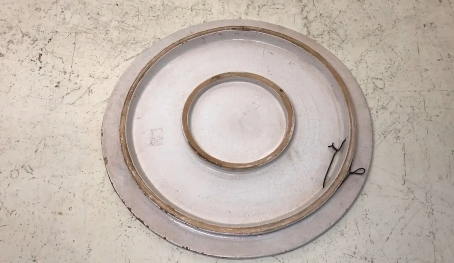 Piatto antico in ceramica bianca con dettagli sul bordo.