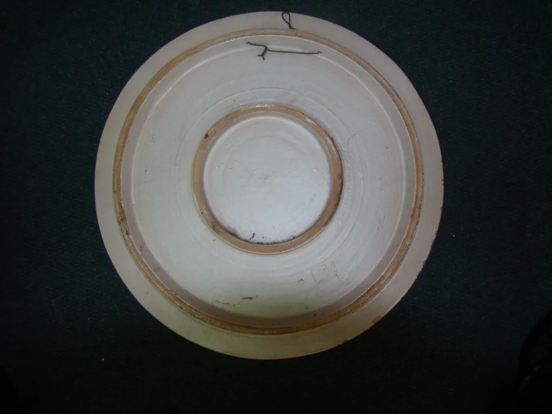 Piatto in ceramica antica con dettagli decorativi.