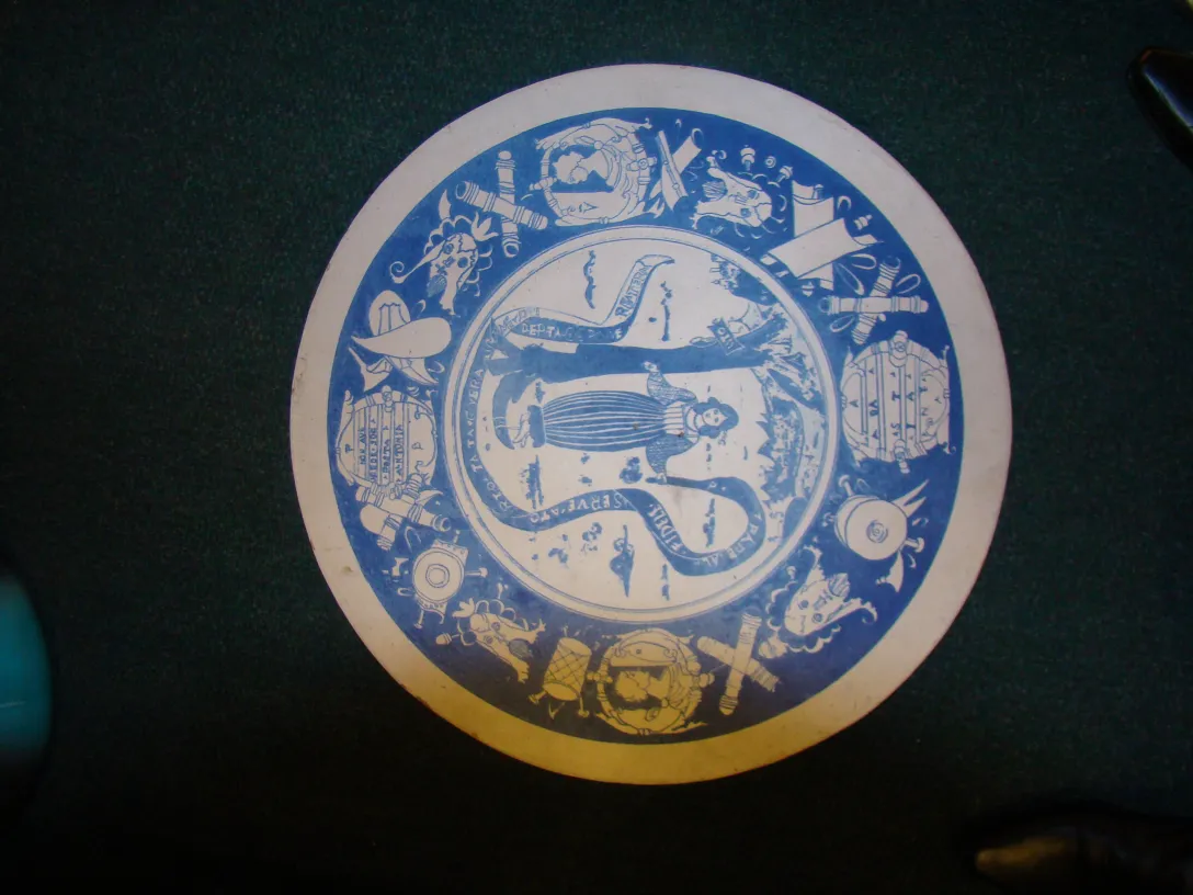 Antiker Keramikteller mit blauen und weißen Designs, eleganter Hintergrund in grün.