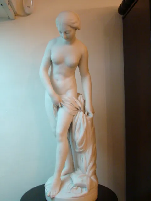 Sculpture ancienne d'une figure féminine debout, geste subtil.