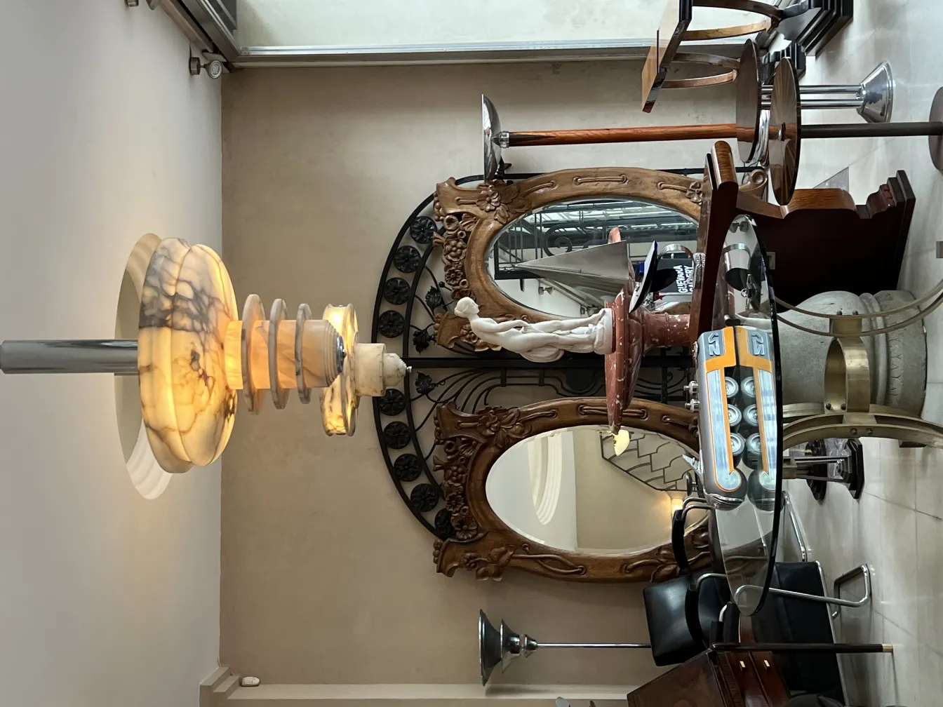 Escultura antiga em um ambiente decorativo com espelhos.