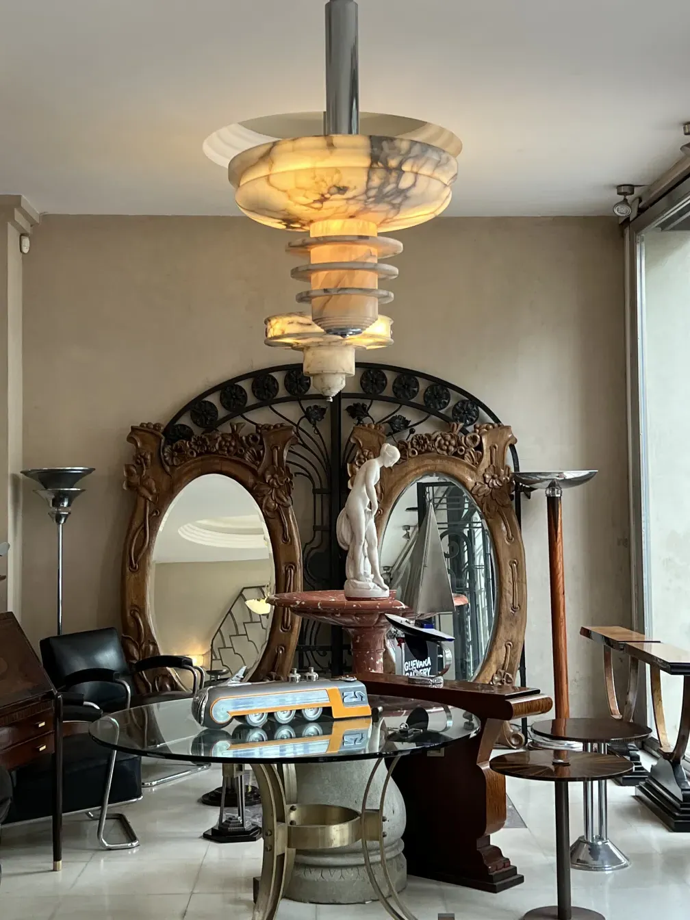 sculpture antique entre miroirs et meubles vintage