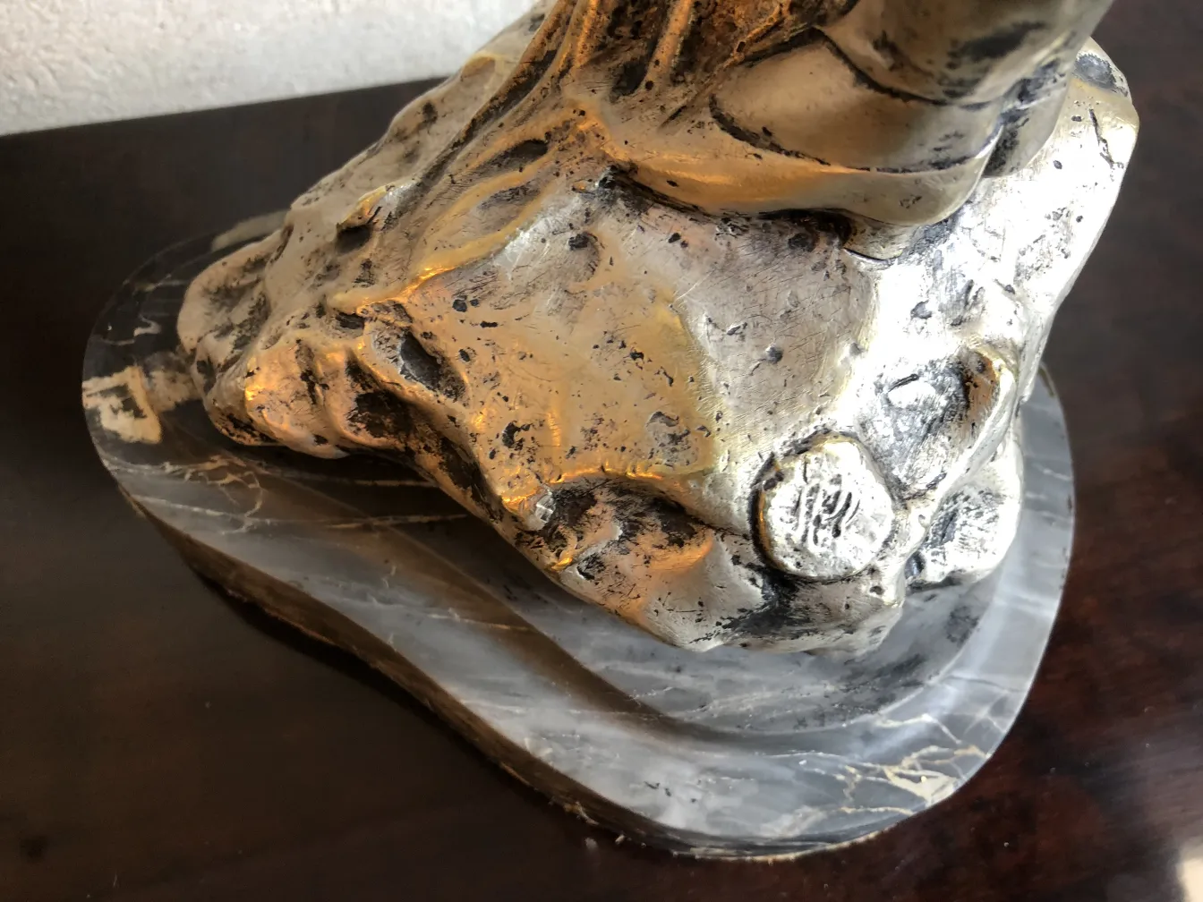 alte bronzene Skulptur auf einem Sockel mit detaillierten Texturen