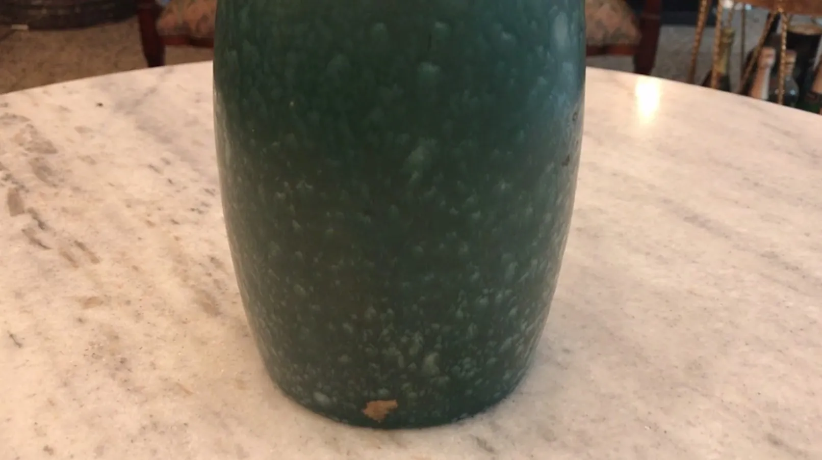 Ancienne céramique verte avec texture unique sur la table.