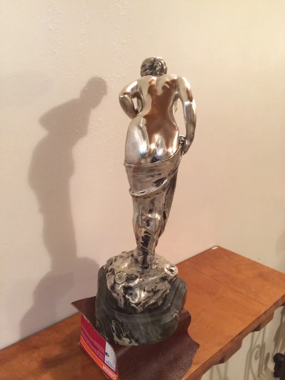 Escultura antigua de figura femenina, detalle de la parte trasera