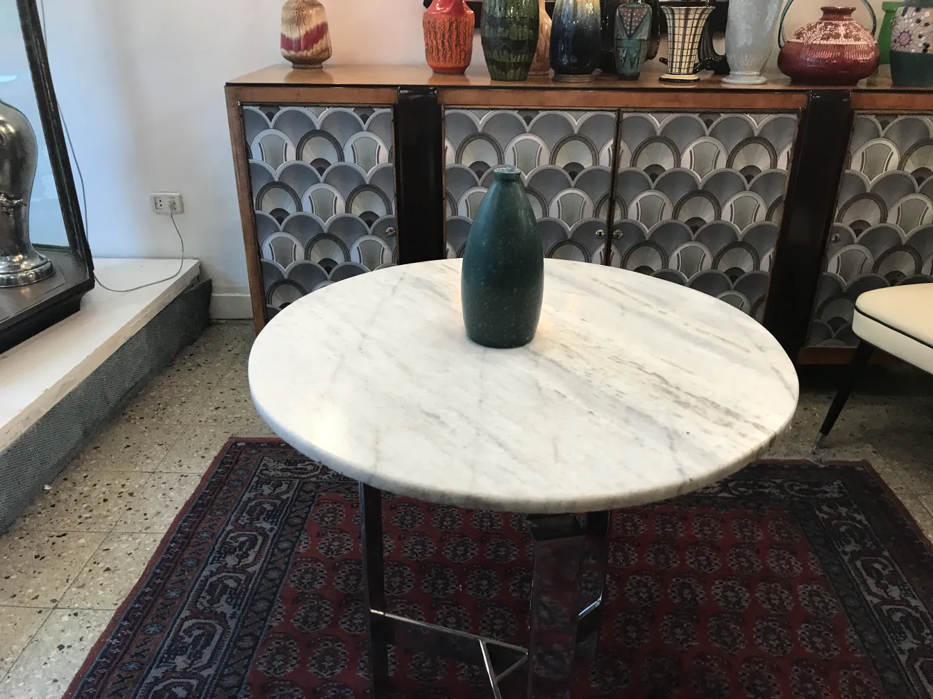 Jarrón de cerámica antigua sobre mesa de mármol con fondo decorativo