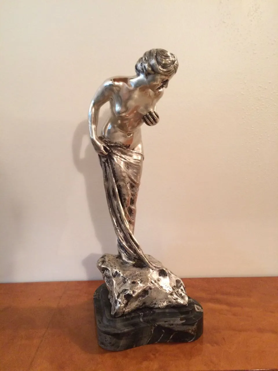 escultura antiga de figura feminina com detalhes e brilho