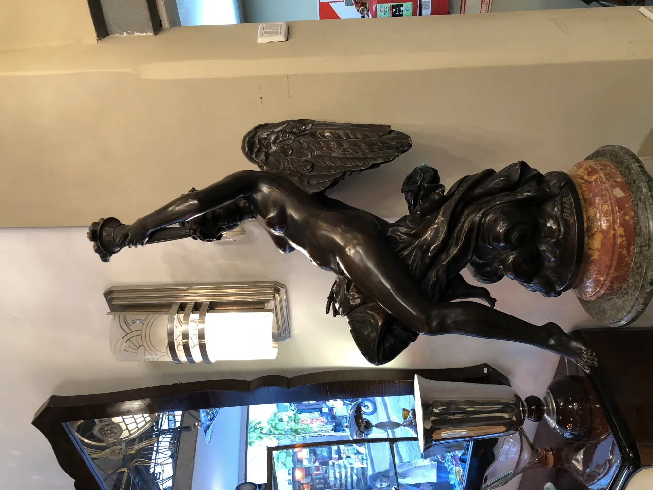 escultura antigua beer con alas y figura esbelta en un entorno decorativo