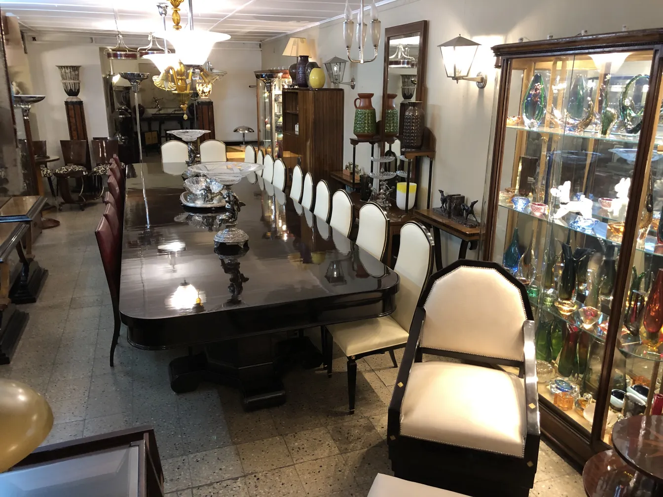 Mesa antigua con cerámica decorativa y lámparas