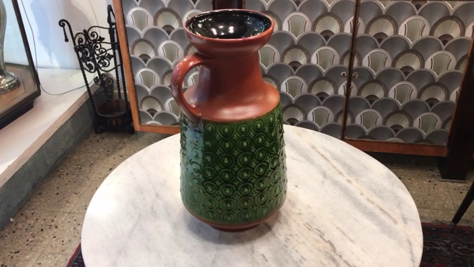 antica brocca in ceramica con decori verdi e marroni