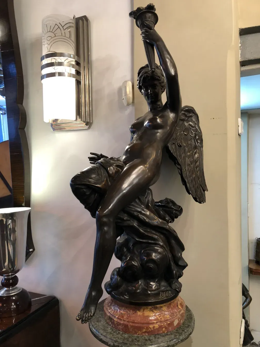 scultura antica di una figura femminile con ali in un ambiente elegante