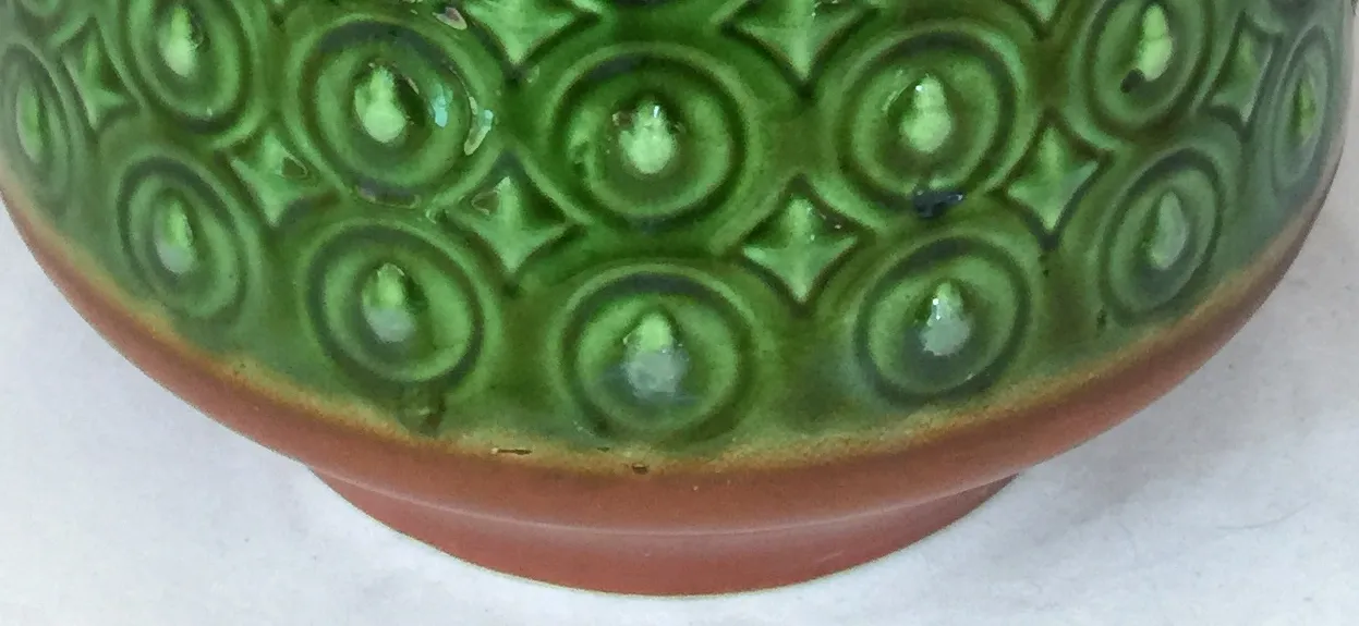 Antique green ceramic with decorative designs and elegant shape.