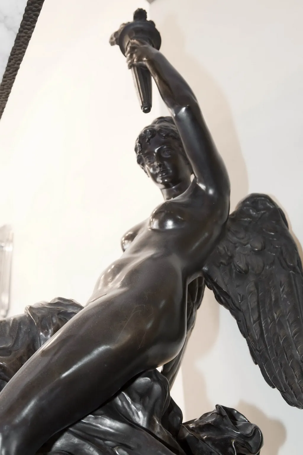 escultura antigua de un ángel sosteniendo una espada en un entorno luminoso