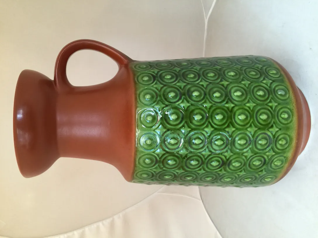 Giara di ceramica antica con decorazione verde e forma circolare.