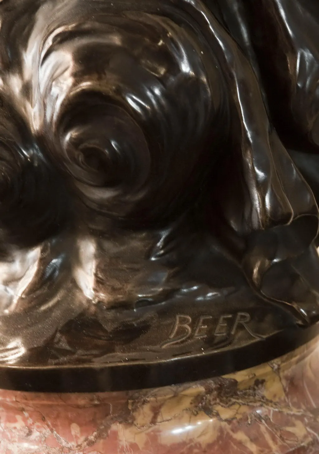 Scultura antica con dettagli elaborati e la firma Beer.