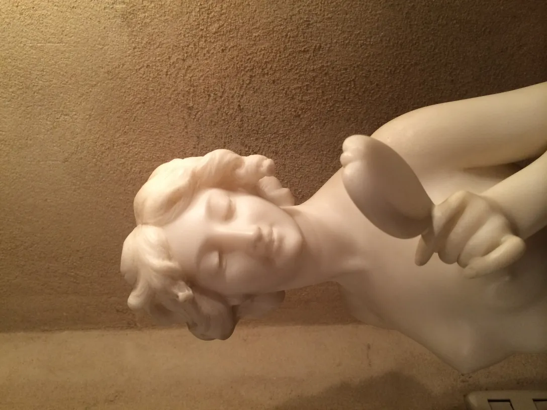 Ancient sculpture of a female figure with soft details and serene expression.