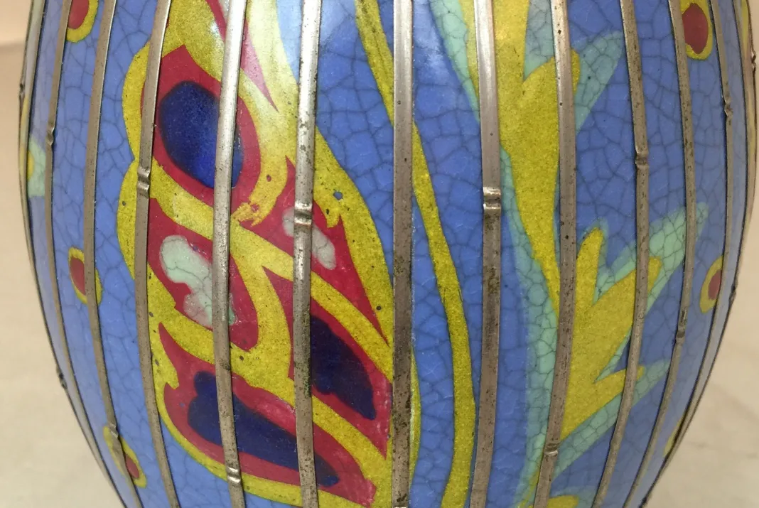 Bunter antiker Keramikvase mit dekorativen Mustern in Blau und Gelb.