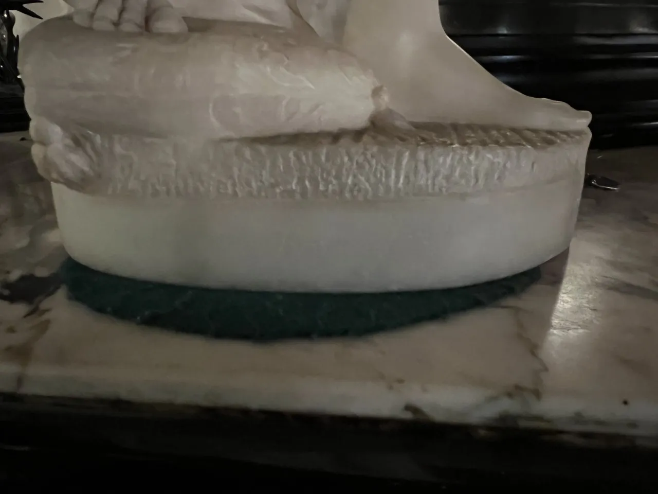 detalle de escultura antigua con base en mármol