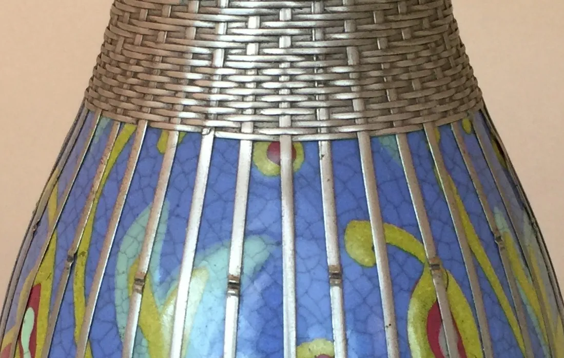 Vaso de cerâmica antiga com padrões coloridos e texturas interessantes em ambiente suave.