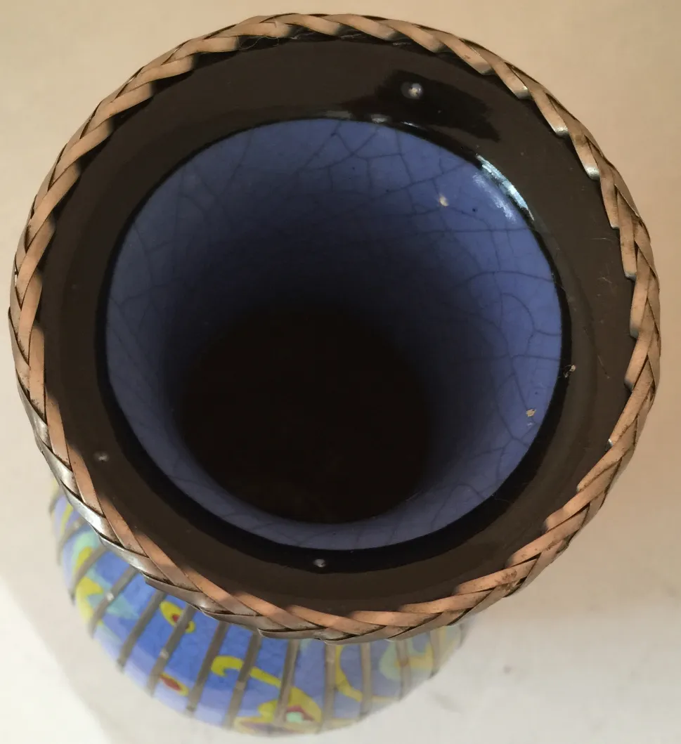 Taza antigua de cerámica con interior azul y diseño amarillo sobre fondo blanco