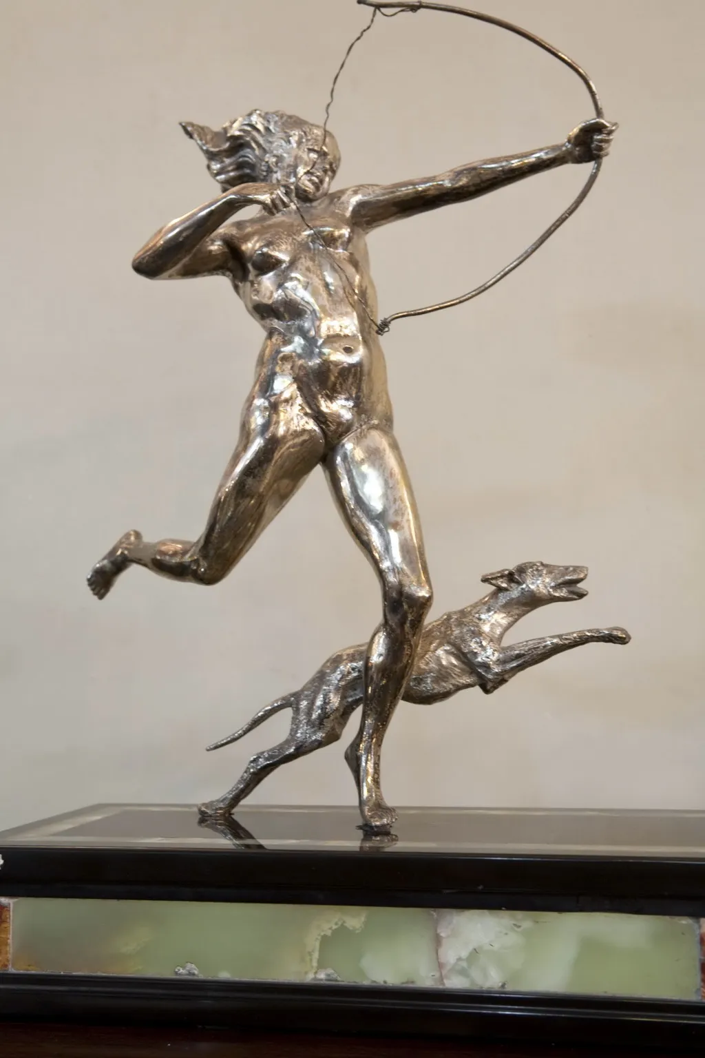 scultura antica di un giovane arciere con un cane che corre