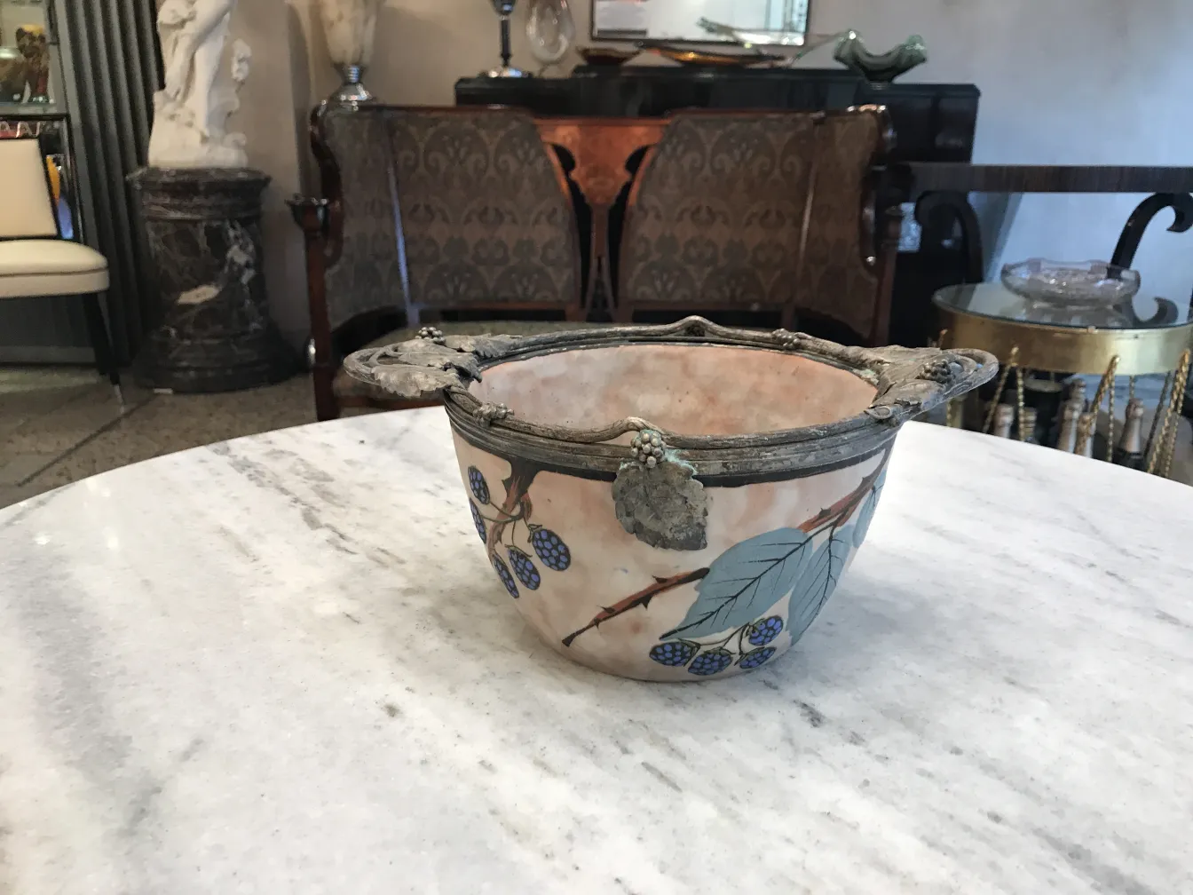 Bella ceramica antica con decorazione di foglie e bacche in un ambiente elegante.