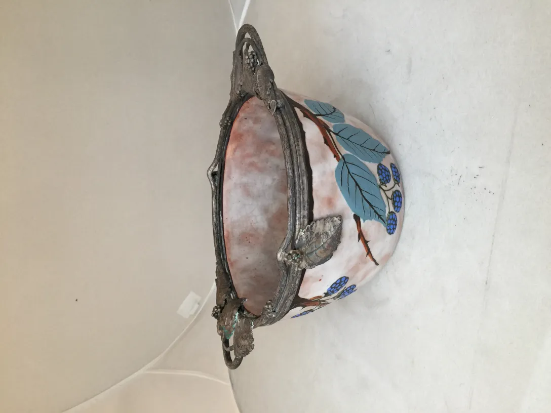 Древняя керамика, украшенная синими листьями и ягодами, в нейтральной обстановке.