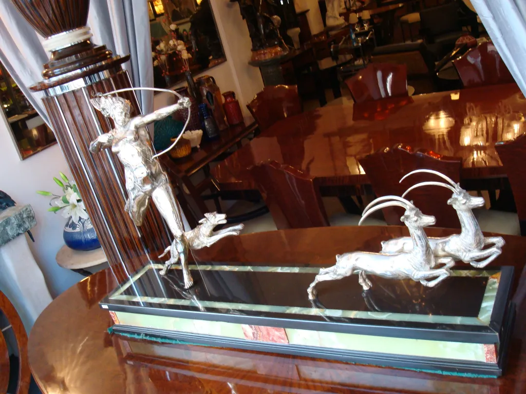 antique sculpture of a hunter shooting a deer in an elegant setting