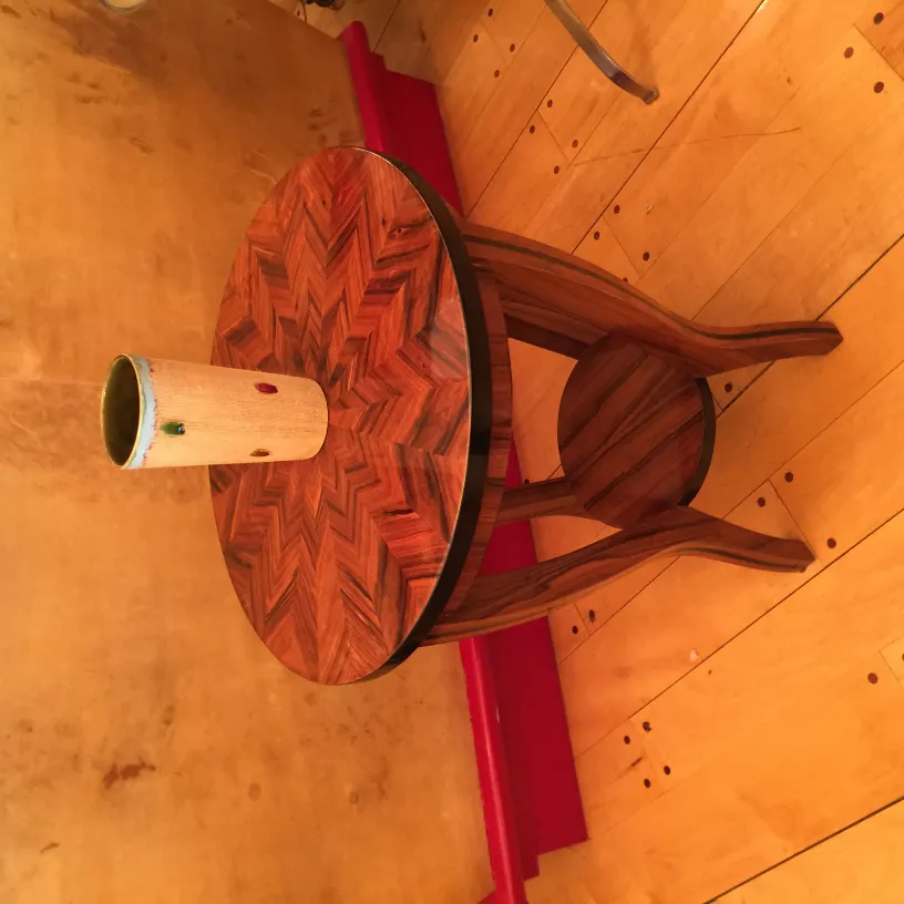 Vaso de cerâmica antiga sobre mesa decorativa em ambiente quente.