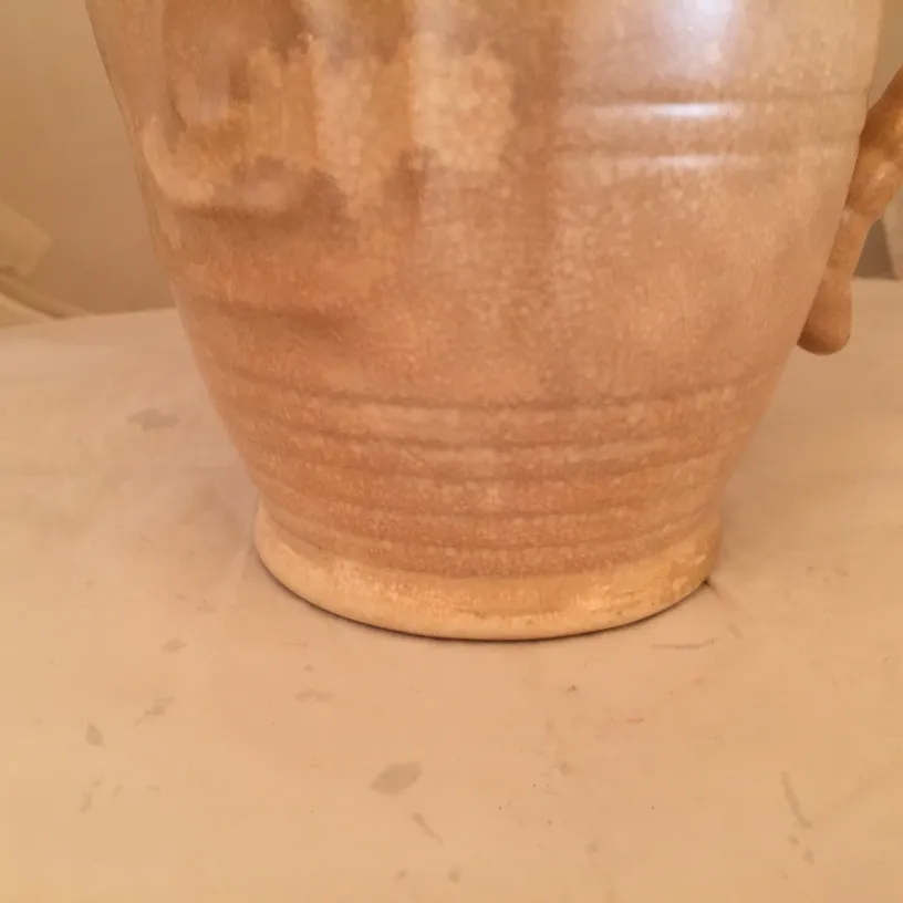 Vaso de cerâmica antiga com textura suave e acabamentos simples.
