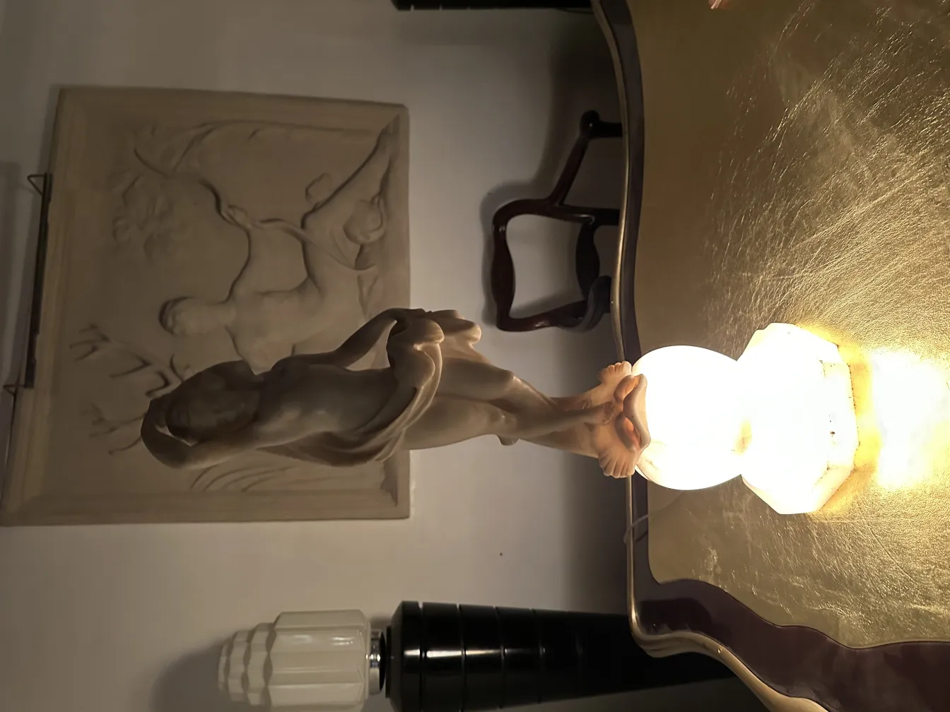 Antique sculpture of a human figure with a decorative background