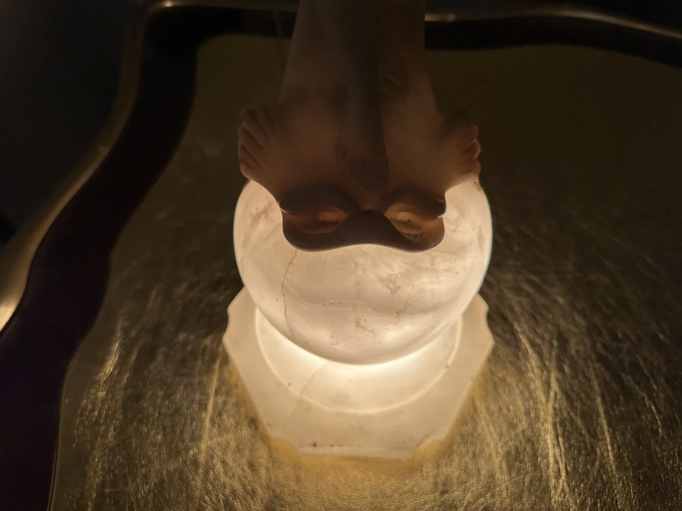 Escultura antiga de figura elegante com base iluminada