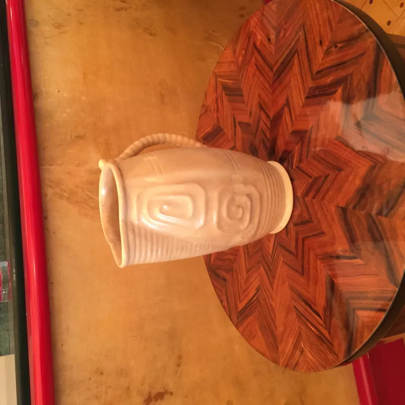 Vaso de cerâmica antiga com decoração única, fundo estilizado.