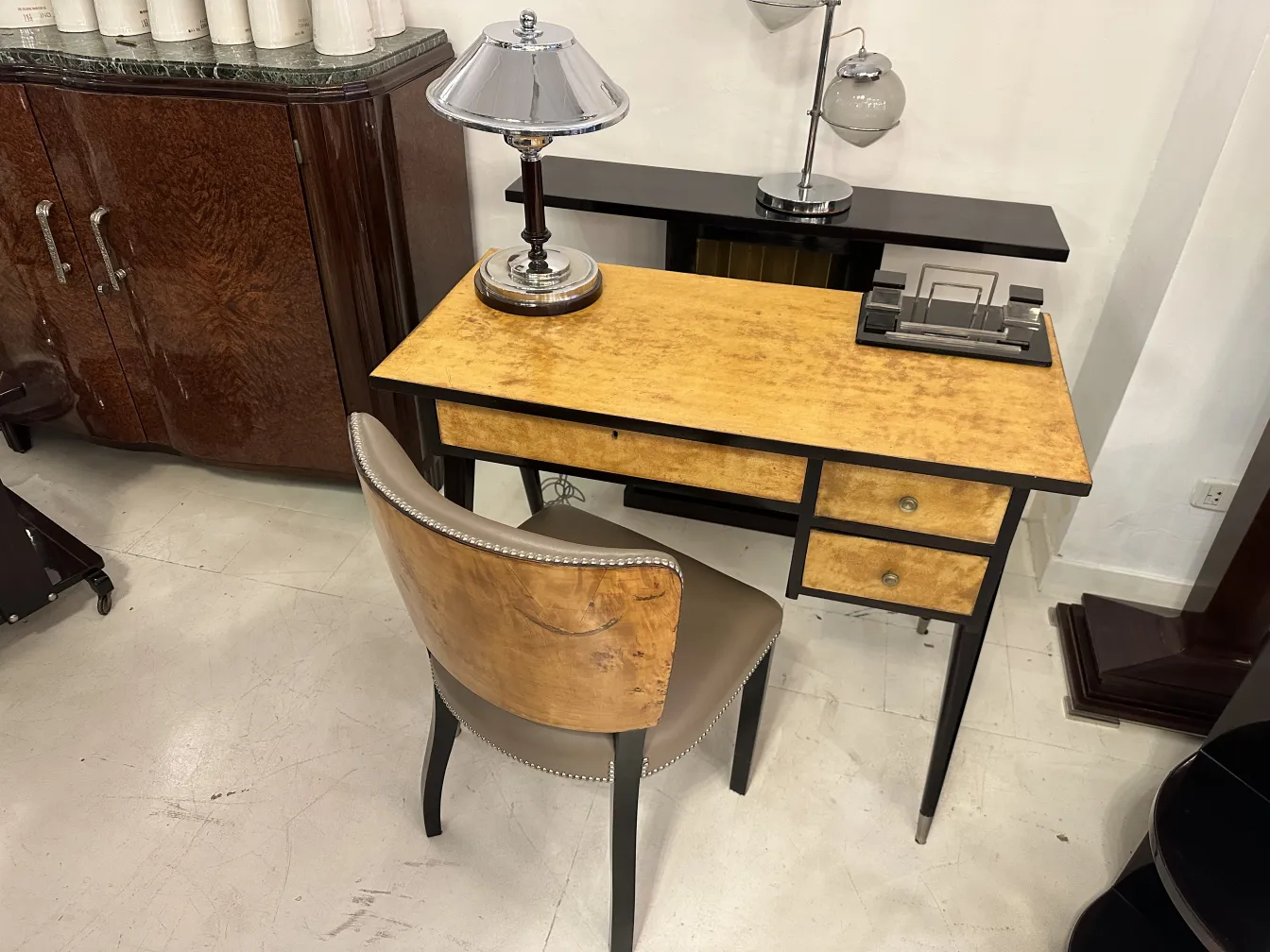 escritorio antigo com acabamento claro e cadeira elegante em ambiente estiloso