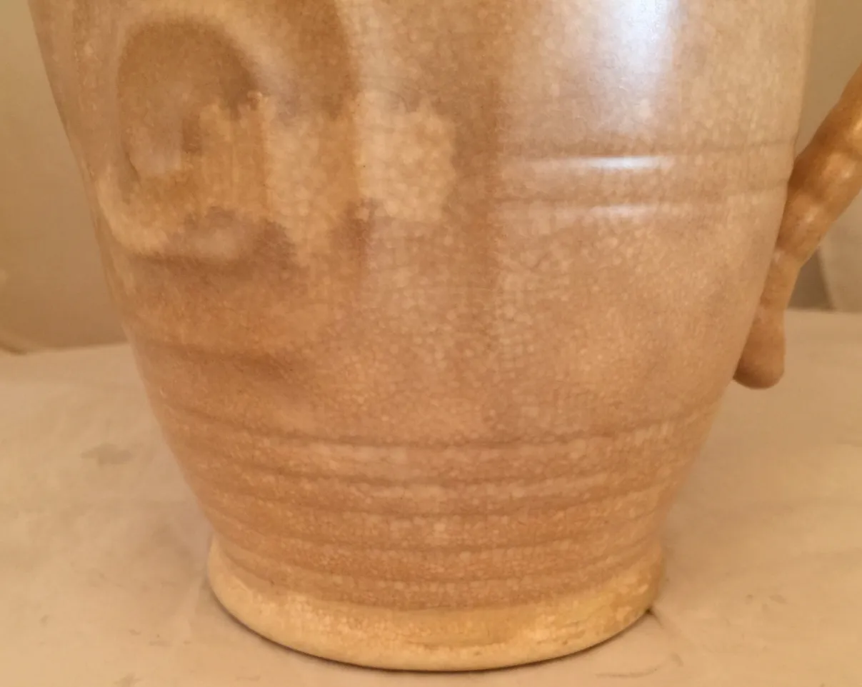 Jarros de cerâmica antiga com textura lisa e tom bege, ambiente acolhedor.