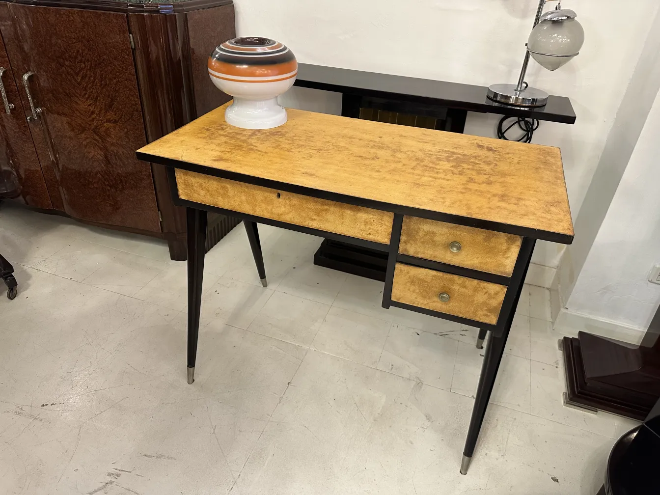 escritorio antigo com superfície amarela e duas gavetas, ambientado em um estilo clássico.