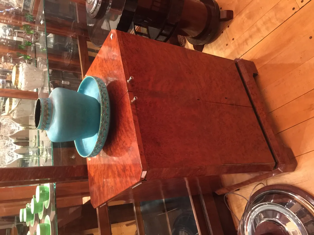 Céramique ancienne de style classique avec décoration bleue et verte, sur un support en bois.