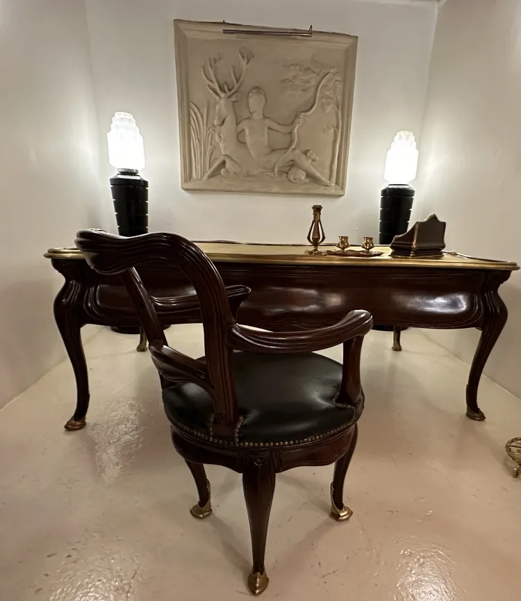 Escritorio antiguo Gustave Keller en una habitación luminosa con una lámpara de luz suave.