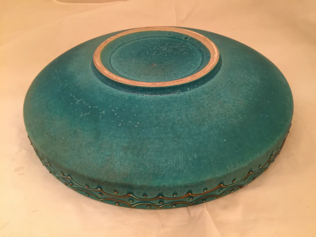 Ciotola di ceramica antica con finitura blu e dettagli dorati.