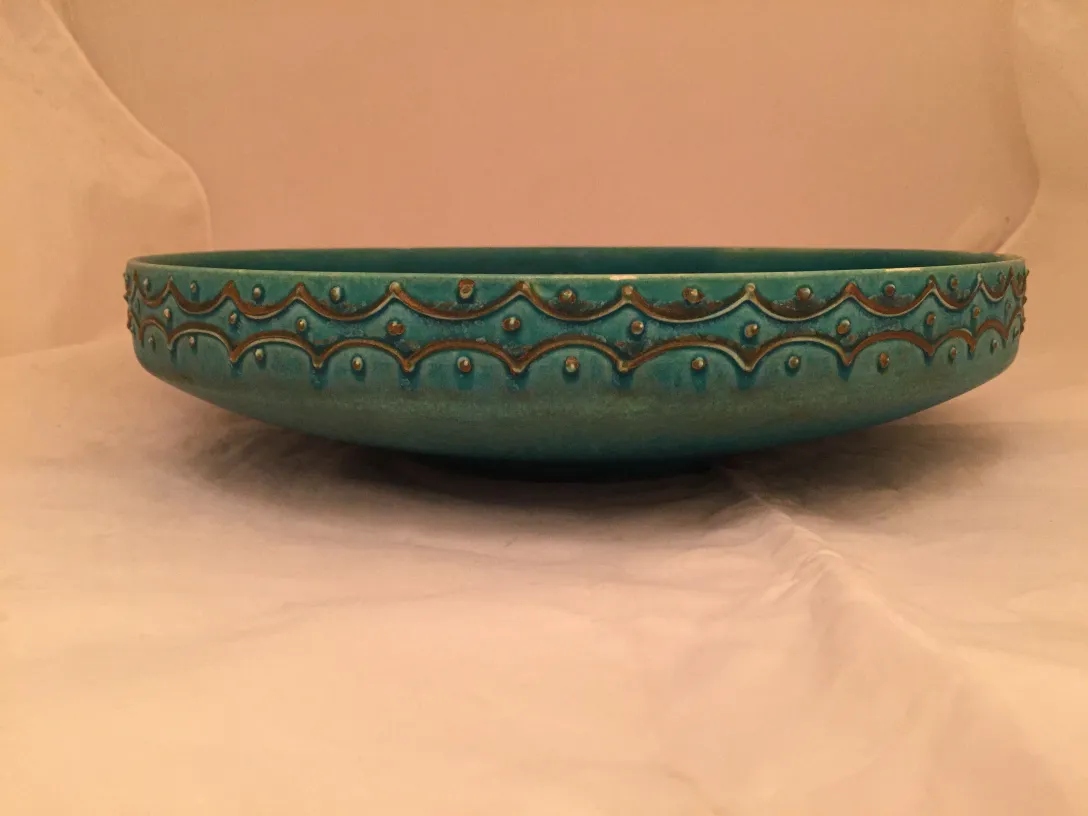Antique turquoise ceramic bowl with wavy patterns
