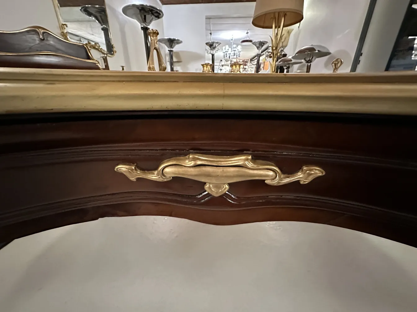 escritorio antiguo con un acabado dorado y detalles decorativos