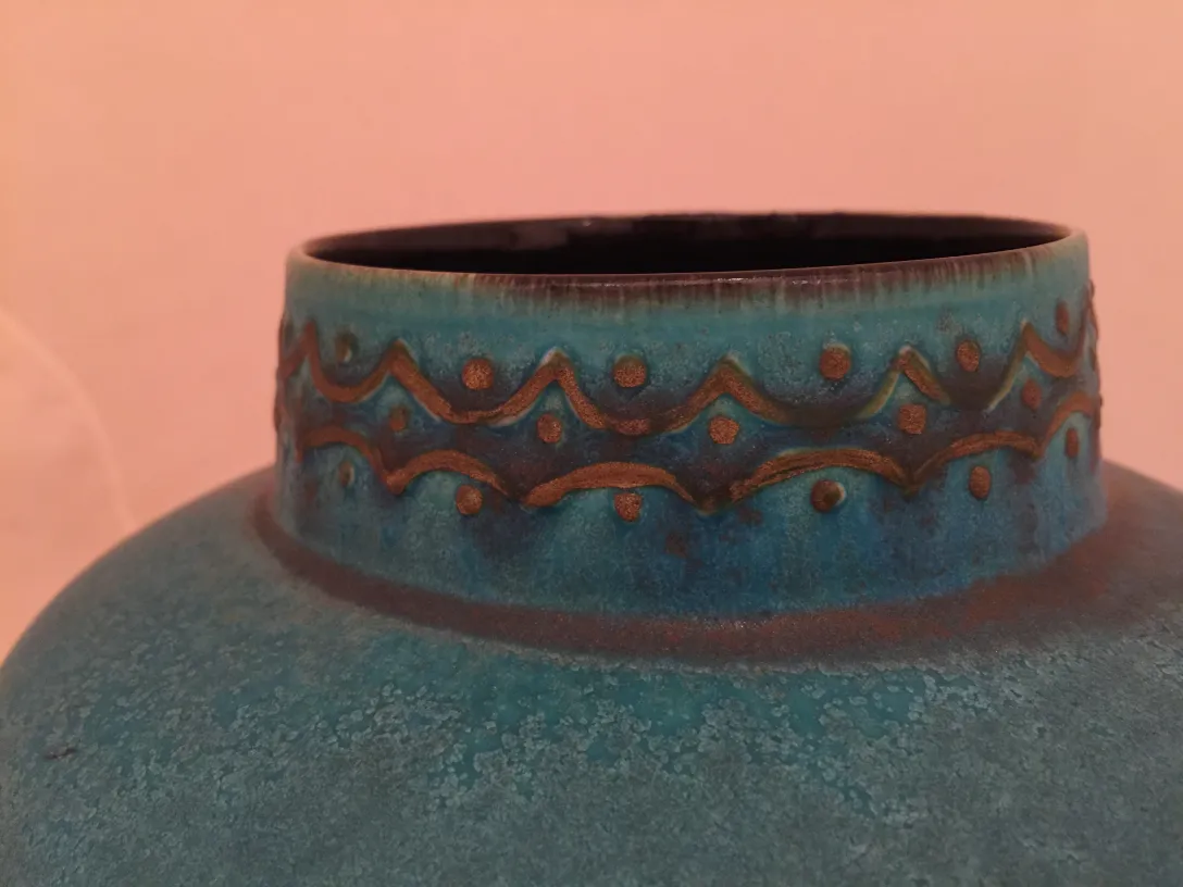 Antike blaue Keramikvase mit erhöhten Mustern.