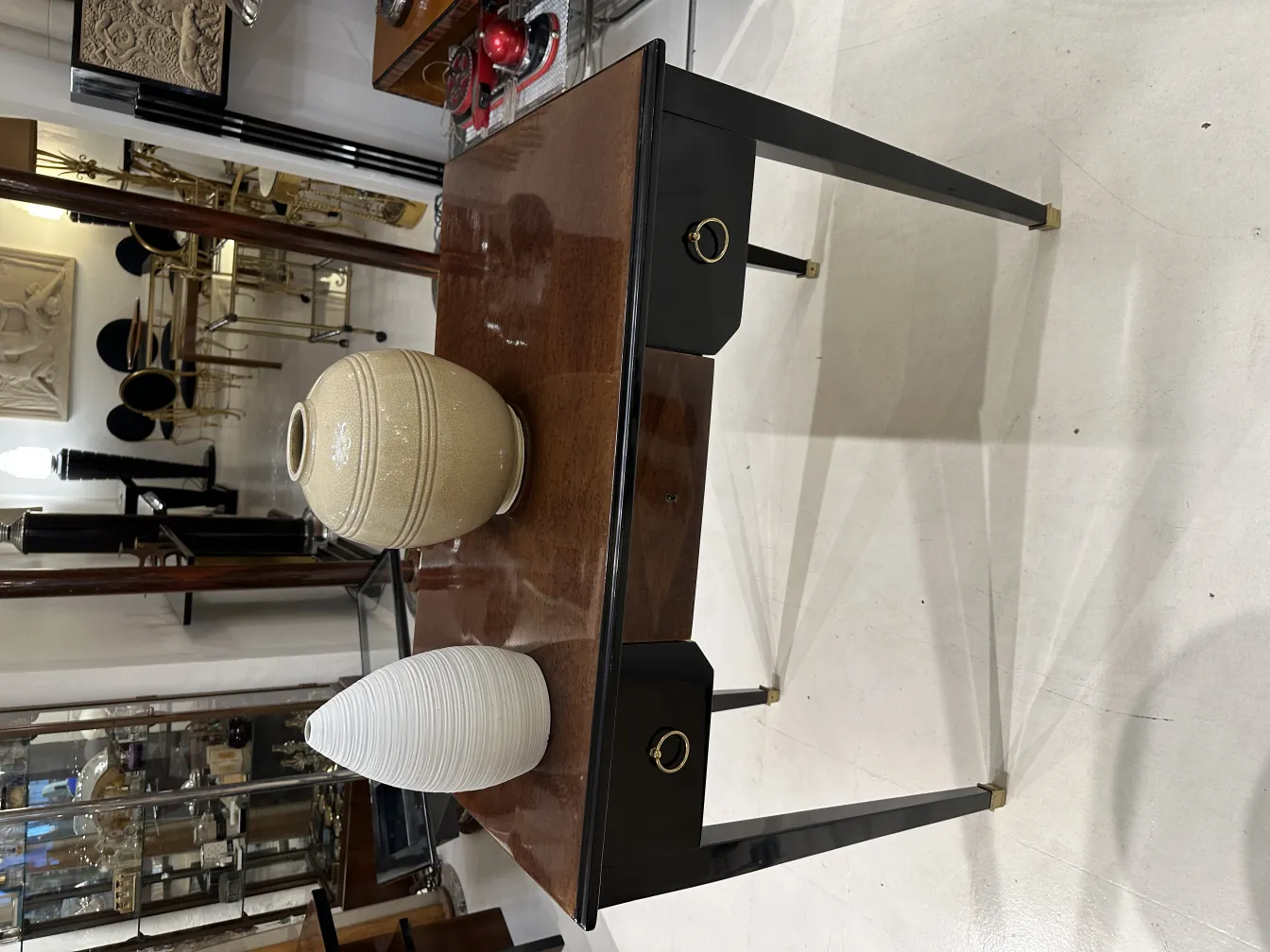 Deux vases de céramique décorative sur une table ancienne, avec arrière-plan d'objets vintage.