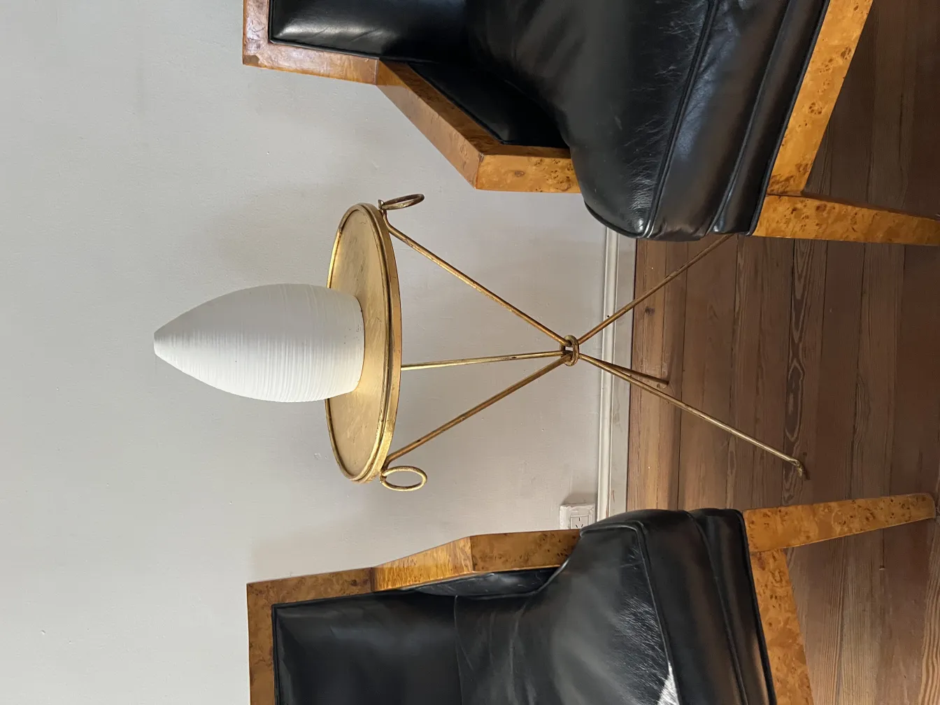 Antike Keramik auf einem goldenen Tisch mit schwarzen Stühlen.