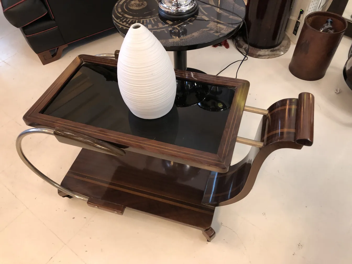 Vaso de cerâmica branca em mesa antiga com acabamentos elegantes