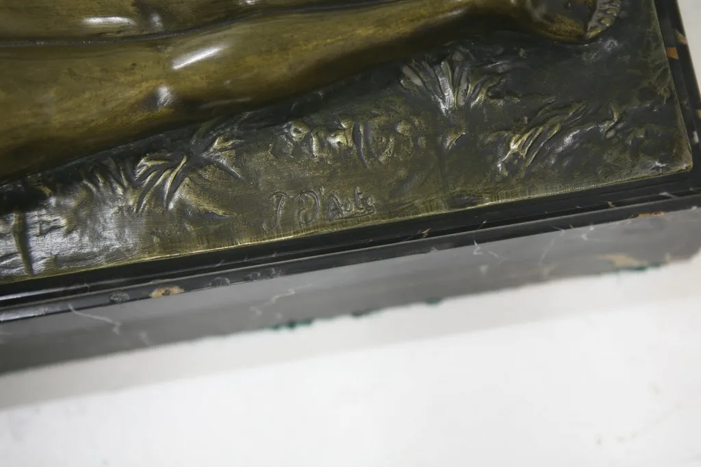 scultura antica con dettagli vegetali e figure, firmata