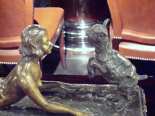 Scultura antica che rappresenta una donna e un cane in un ambiente elegante.