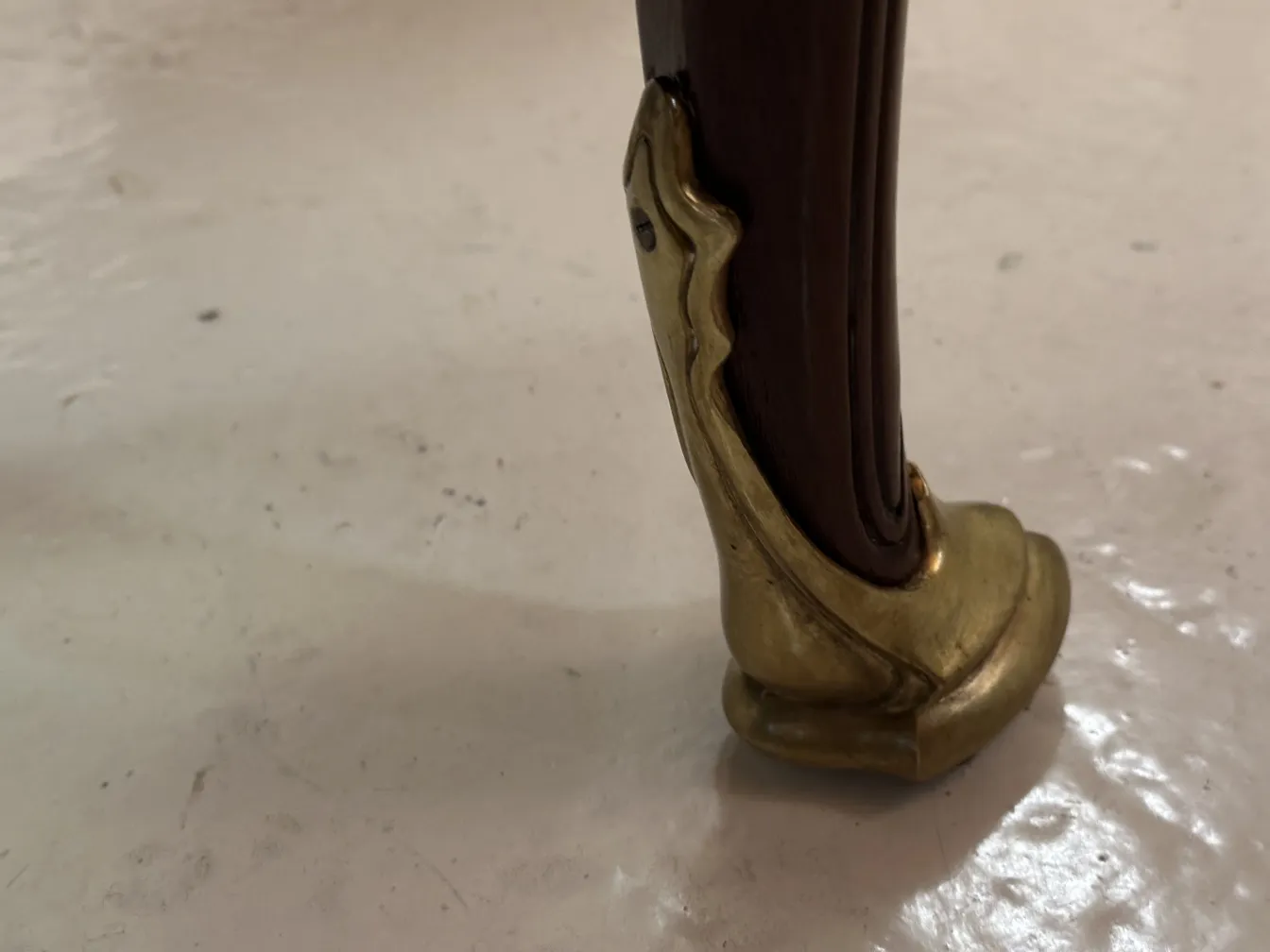 Détail d'une patte de bureau antique avec une finition dorée.