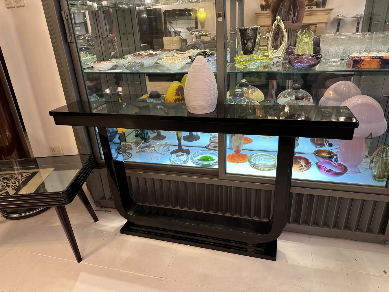 黑色桌子上的白色陶瓷花瓶和玻璃展示柜